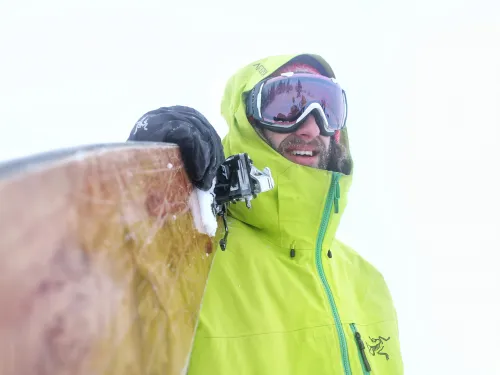 Skier holding skis looking down the barrel Dax Justin