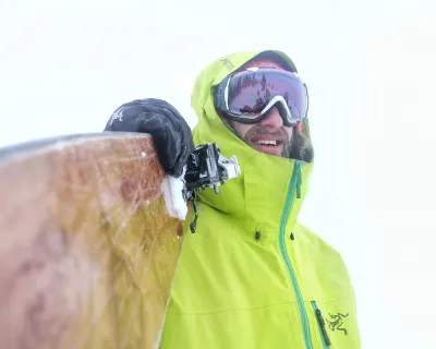 Skier holding skis looking down the barrel Dax Justin