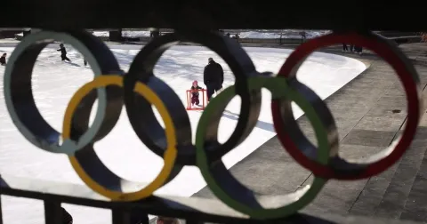 A kid learning to skate at an Olympic skating rank