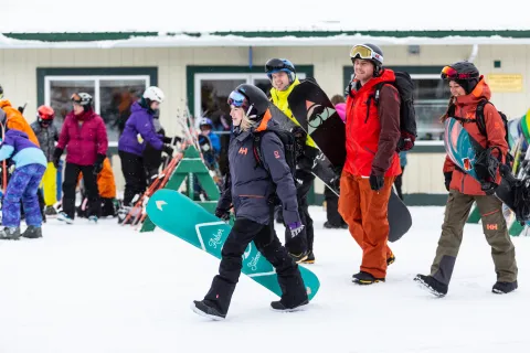 Some snowboarders walking in Castle Mountain to hit the slopes