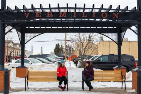 Two people sitting on a bench in downtown Vermillion