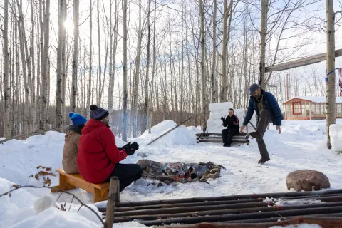 4 people around a fire during the winter